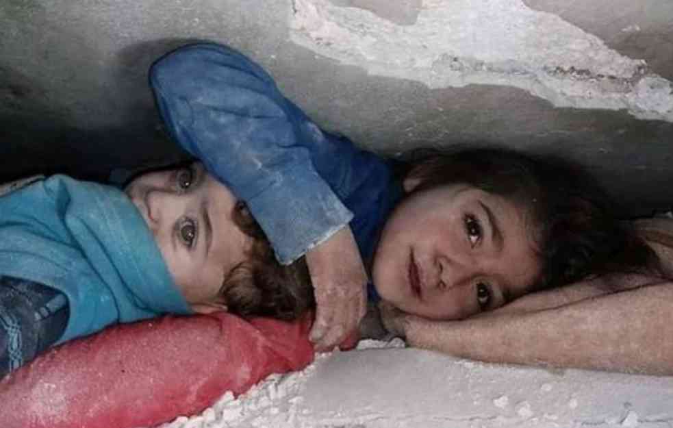 Una bambina protegge il fratellino con le mani tra le rovine del palazzo (FOTO e VIDEO)